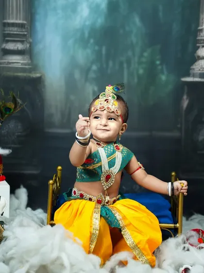 Our Krishna theme is a divine celebration. I meticulously craft every detail, from the ornate jewelry and peacock feather to the dreamy backdrop, to create a portrait that feels like a timeless painting.