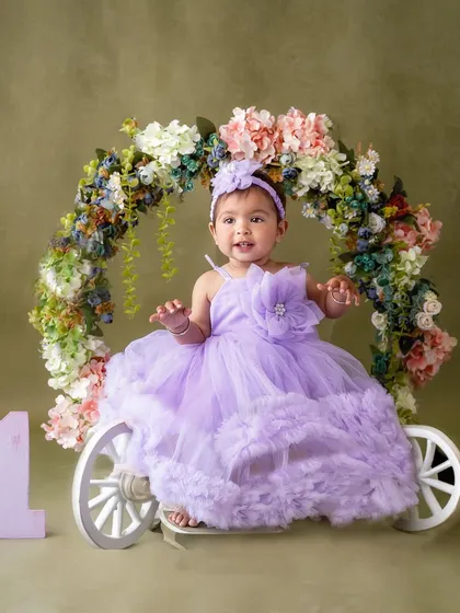 Seated in her beautiful floral carriage, this baby girl is the picture of first birthday elegance and joy.