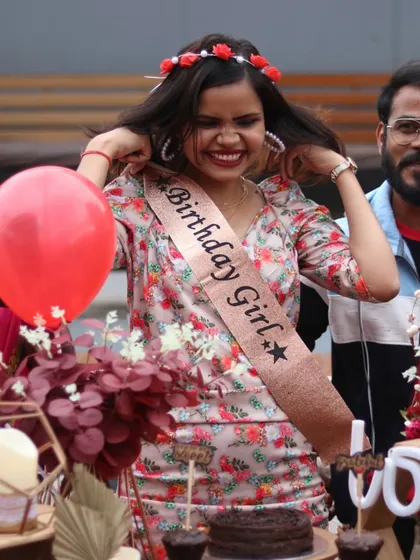 We sell happiness. A birthday girl with a sash and flower crown beams with joy at her celebration.