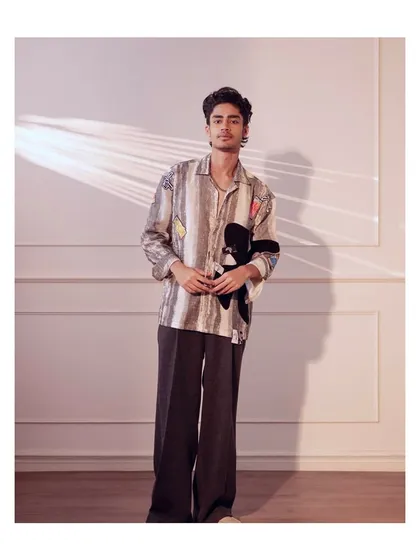 This look combines a uniquely printed, relaxed fit shirt with wide leg trousers. It is an artistic and comfortable choice for the man with a distinct sense of style.
