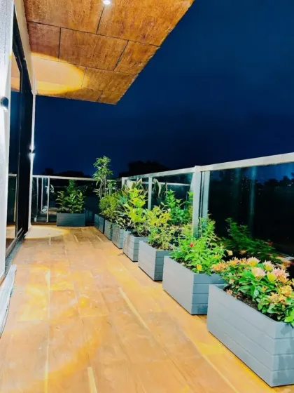 A full view of the illuminated terrace deck, demonstrating how a well-planned layout provides ample room to walk and enjoy the greenery, even in a long, narrow space.