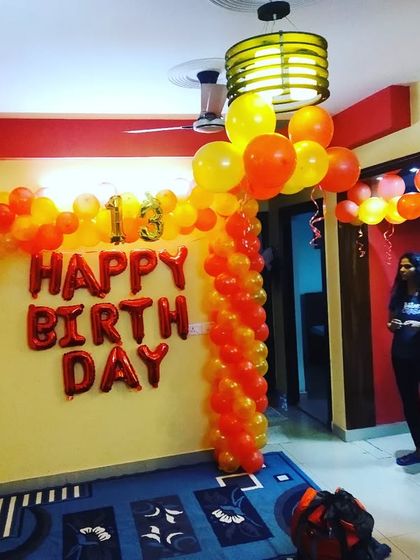 A 13th birthday party decoration in a home, using red and yellow balloons to create a vibrant atmosphere.