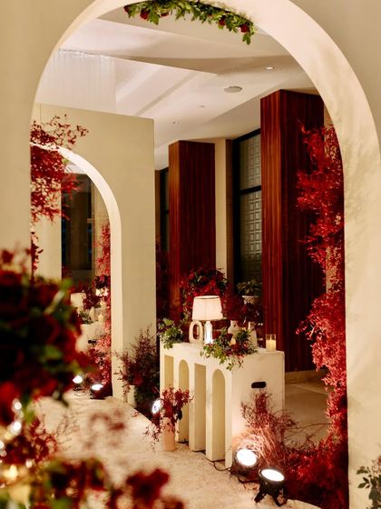 A beautifully lit corner of the reception, with a modern console table, a table lamp, and red floral arrangements creating a warm and inviting nook.