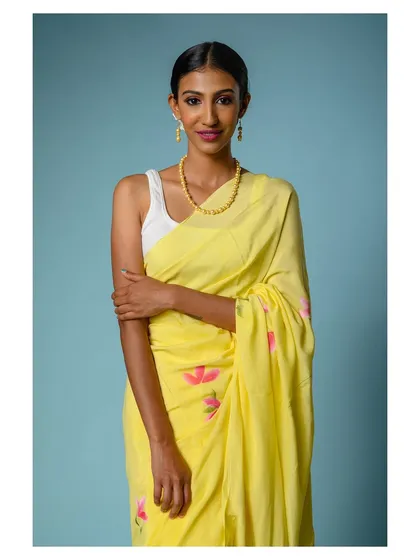 A close-up portrait of the model in the yellow saree, giving a better view of the neckline and jewelry.