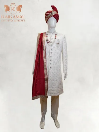 The quintessential royal groom's attire. This is my classic all-white, intricately embroidered sherwani, perfectly complemented by a rich maroon stole and a matching turban for a look of timeless elegance on your wedding day.