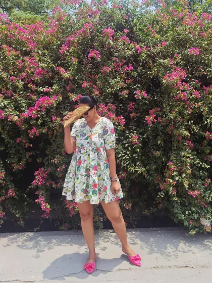 A playful moment in a floral mini dress against a backdrop of bougainvillea. This is a perfect, easy-to-pack dress for any sunny destination.