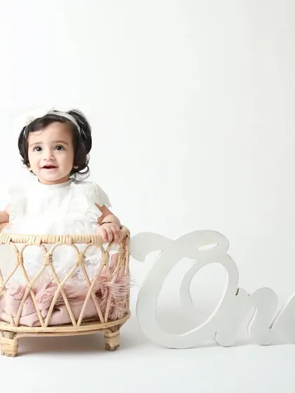 A classic first birthday shot in a wicker basket with the 'One' sign. Timeless and sweet.