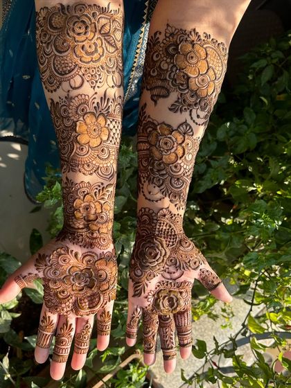 The full view of this stunning floral mehendi. The patterns are a mix of large, open flowers and smaller, detailed buds.