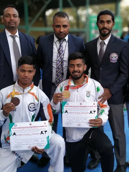 Two of my dedicated students after winning medals at the district karate championship. Posing with officials, they have earned their spot to compete at the state level.