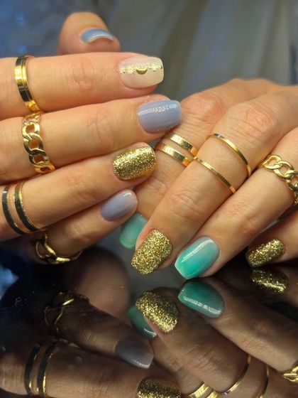 A full view of the stylish multi-colored and glittery nail set.