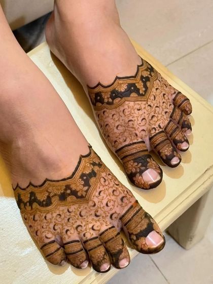 A bold and beautiful foot mehandi with full coverage. The design uses negative space to create a striking floral pattern across the feet.
