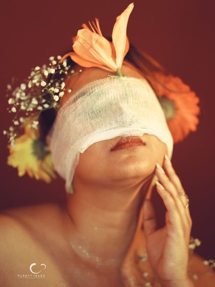 A conceptual portrait about inner beauty. Though her eyes are covered, she is adorned with flowers, suggesting that true beauty blooms from within.