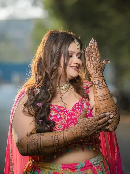 Showcasing her beautiful henna design. The bride's makeup is kept fresh and radiant, ensuring her natural glow is the highlight of her Mehendi look.