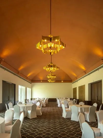 The expansive banquet hall at the Bodhgaya hotel, featuring a vaulted terracotta ceiling and custom chandeliers. The design creates a space that is both grand for events and warm for intimate gatherings.