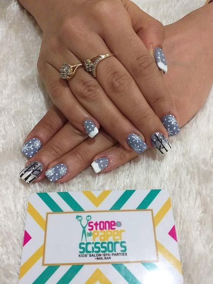 A winter-inspired design with a grey and white color palette. I painted delicate snowflakes and graphic lines to create a cozy, seasonal look on these short square nails.