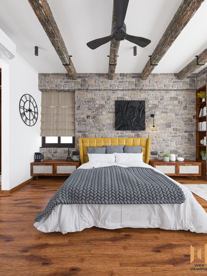 The bed's vibrant yellow headboard provides a beautiful contrast against the grey stone wall and chunky knit throw.