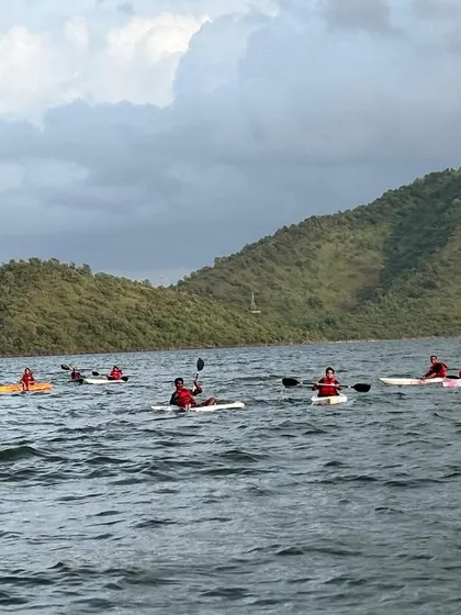 A group of kayakers and paddleboarders enjoy a session on the open water, showcasing the variety of activities available at our camps.