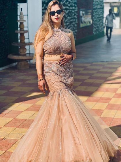 A stunning fish-cut lehenga in a beautiful beige tone. The halter-neck blouse and dramatic flared bottom create a show-stopping silhouette, perfect for making a glamorous statement.
