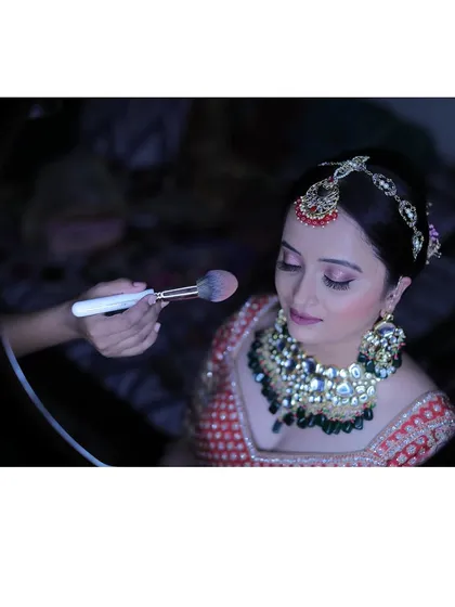 Here’s a little peek at my process. Using professional lighting and tools, I carefully apply makeup to create a smooth, long-lasting finish. This behind the scenes shot shows the final touches being applied for a North Indian reception look.