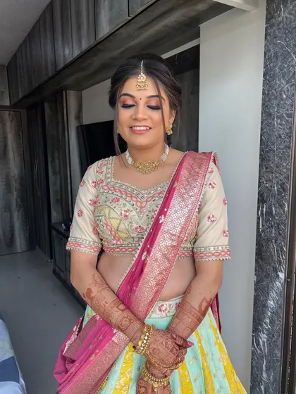A beautiful baby shower bride in a pastel lehenga. The makeup features a soft pink shimmery eye and a flawless base.