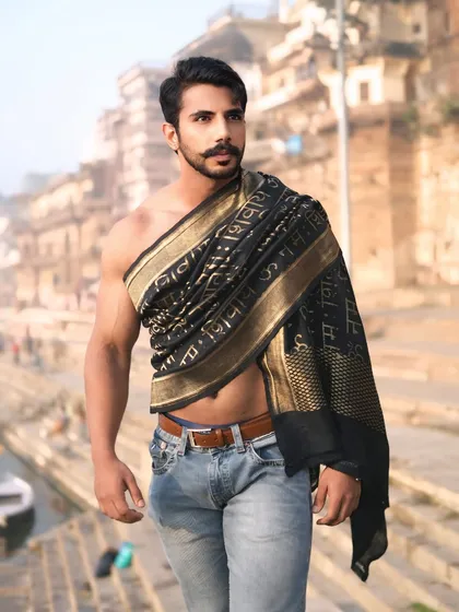 A male model stands confidently at the Varanasi ghats, pairing modern denim with a traditional black and gold shawl. This image represents my signature style of fusing contemporary looks with cultural heritage.