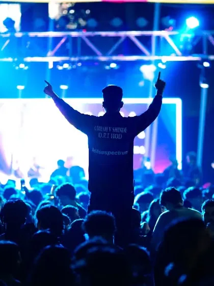 Capturing the peak energy of a college DJ night. This silhouette shot against the bright stage lights shows how I play with light and shadow to convey the electric atmosphere and collective excitement of the crowd.
