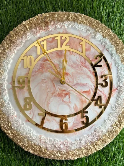 A delicate and pretty clock with a pink and white marble design and a full border of gold and white crystals.