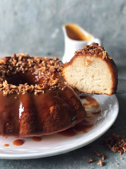 A slice of my vanilla bundt cake, generously drizzled with homemade salted caramel sauce and topped with crunchy candied pecans. A truly comforting dessert.