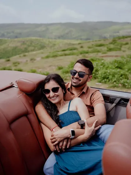 A cozy and candid moment in the backseat of a convertible, with rolling green hills in the background. This shot feels like a scene from a romantic road trip movie.