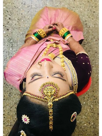 An artistic top-down shot of the bride during her Gouri Pooja, highlighting the stunning matha patti and eye makeup.