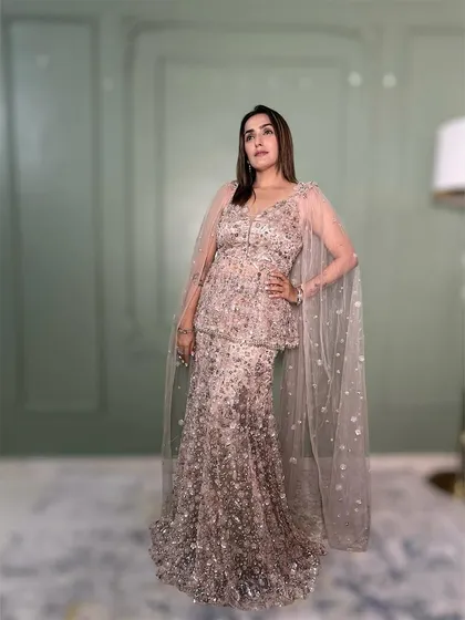 The full view of this beautiful peplum gown with a sparkling cape. It's a perfect blend of modern design and classic elegance.