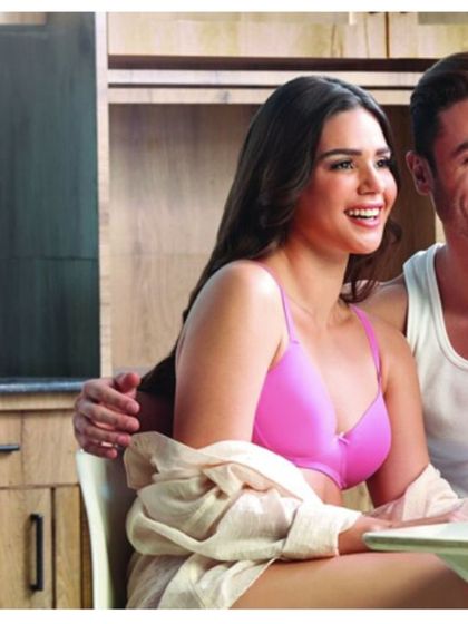 An intimate and happy moment styled for a V-Star innerwear campaign. The casual styling with a tank top for him and a bright bra for her creates a cheerful and natural couple's scene.
