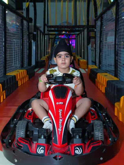 This little driver, wearing a traditional patka, is all set for his go-kart adventure, showing that our play zone is for everyone.