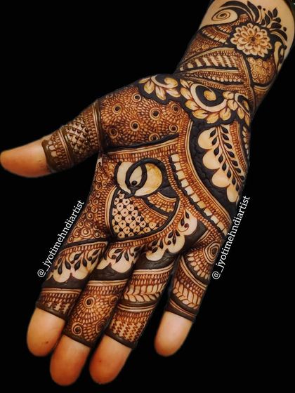 An intricate Indian mehndi design with a central peacock figure. The use of bold lines and detailed patterns creates a captivating look for any bride.