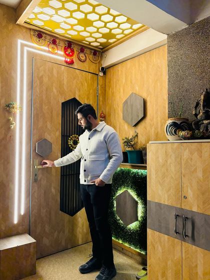 A unique main door and entrance design at Prateek Laurel, featuring wooden paneling, a hexagonal motif, and a beautiful CNC-cut ceiling with a honeycomb pattern.