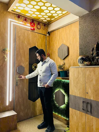 A unique main door and entrance design at Prateek Laurel, featuring wooden paneling, a hexagonal motif, and a beautiful CNC-cut ceiling with a honeycomb pattern.