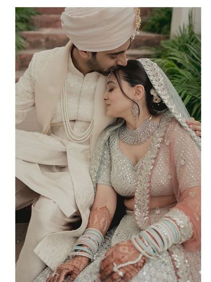 A tender moment between the bride and groom. The bride's soft half updo with a veil is the perfect romantic hairstyle for her daytime wedding.