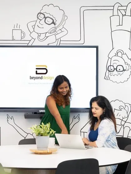 Our team collaborating in a meeting room decorated with fun, custom-drawn cartoons that reflect our creative and playful culture.