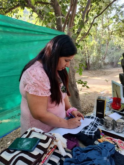 A volunteer carefully logs the items at our thrift stall. We manage our inventory professionally to ensure a smooth experience for both donors and shoppers.