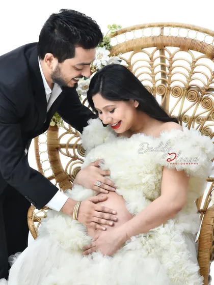 A close-up shot focusing on the hands of both parents cradling the baby bump. This intimate photo beautifully symbolizes their shared love and anticipation.