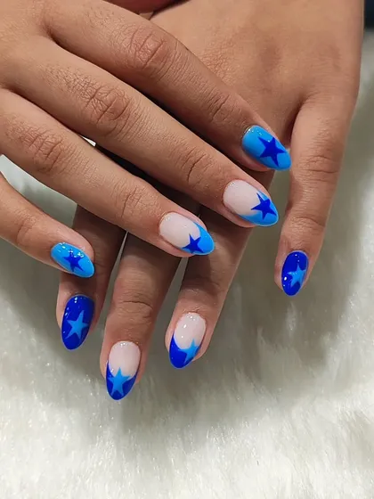 A cool and trendy design featuring different shades of blue. This set includes solid blue nails, French tips, and sheer nails with bold blue star patterns.