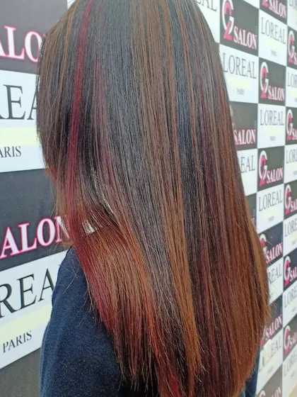 A mix of red and caramel highlights adds warmth and vibrancy to this client's straight hair. The placement of the colors creates a beautiful, multi-dimensional look.