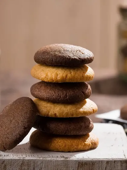 A stack of assorted cookies captured with soft, natural light to emphasize their homemade texture. This style of food photography is great for artisanal bakeries and home-based businesses.