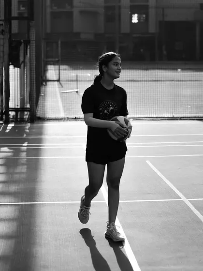 A player walks across the court, ball in hand, with her shadow trailing behind. A simple, yet powerful image of a player in her element.