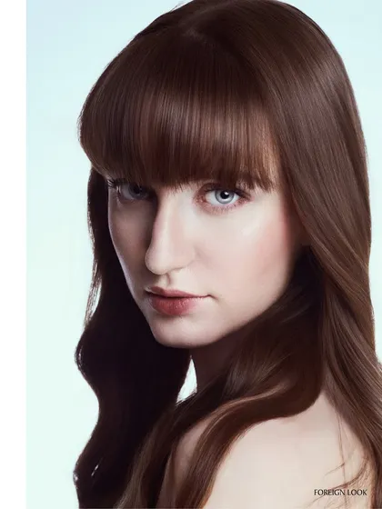 A commercial beauty headshot perfect for a hair care brand. The lighting is soft and even, emphasizing the healthy shine and smooth texture of the hair.