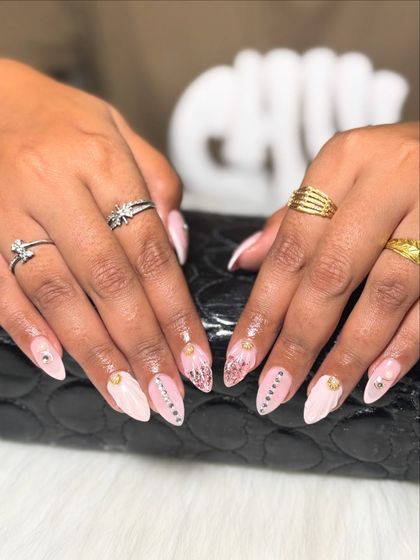 Intricate and detailed nail art for a bride who wants something unique. This set combines textured patterns, glitter, and carefully placed stones on a soft pink base.