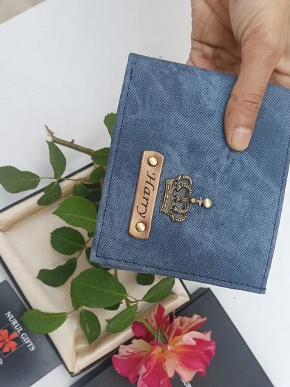 A lifestyle shot of the blue denim wallet, showing its texture and quality.