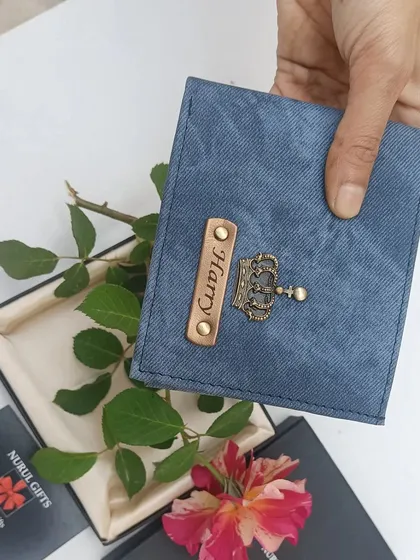 The personalized blue denim wallet held over its gift box with a rose, highlighting its gifting potential.