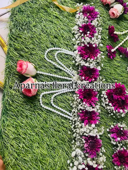 A close-up of the intricate floral belt, made with magenta flowers and accented with pink rosebuds.