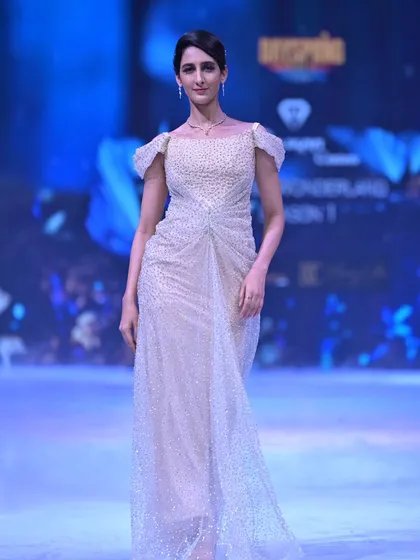 Another look at the golden Swarovski-adorned gown, showcasing its radiant sparkle as it moves down the runway.